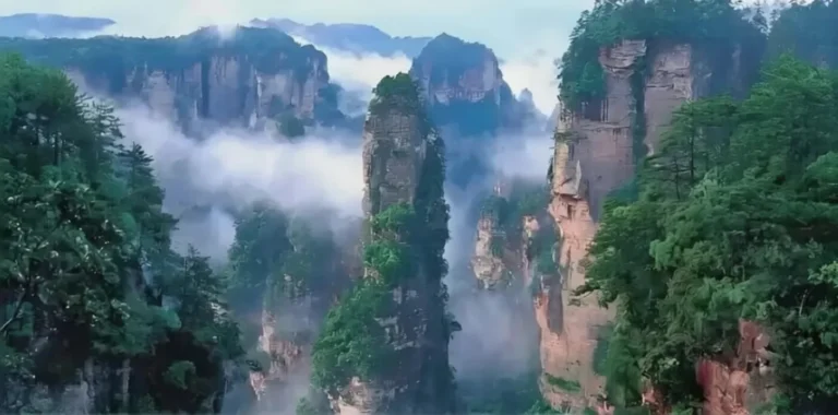 Spring mist covering sandstone pillars at the best time to visit Zhangjiajie China