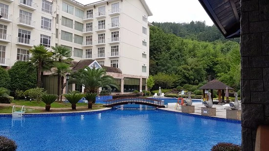Outdoor swimming pool at Pullman Zhangjiajie hotel with tropical gardens and peaks