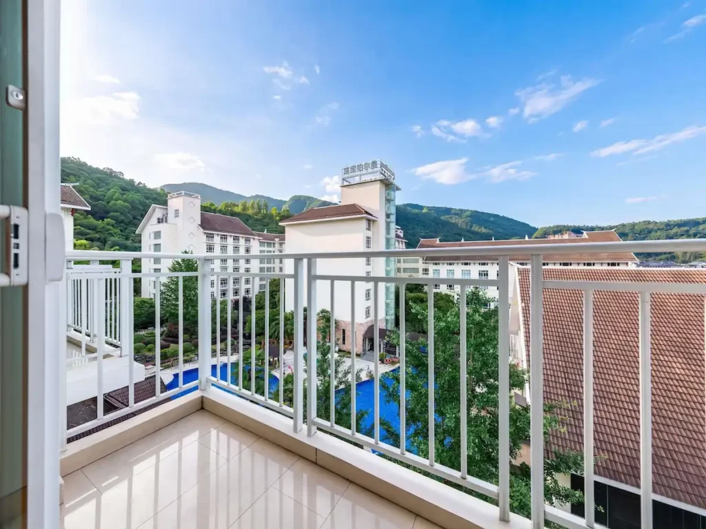 Pullman Zhangjiajie Hotel deluxe room balcony view pool and karst mountains