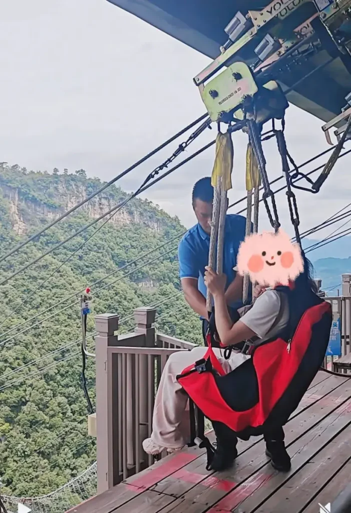 Staff weighing a rider before the Zhangjiajie zipline