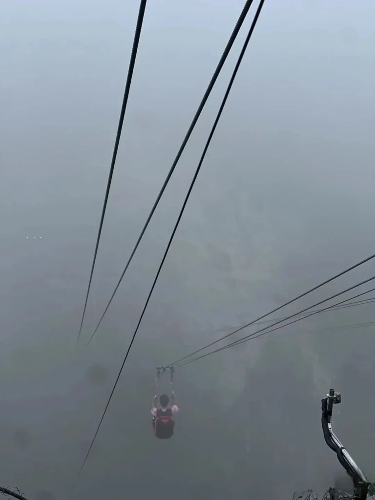 Tourist riding the Zhangjiajie zipline over the Grand Canyon
